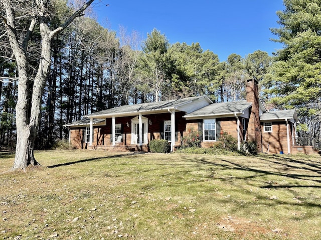 ranch-style house with a front yard and covered porch