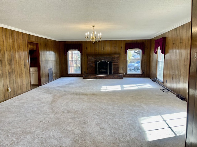 unfurnished living room featuring wooden walls, carpet floors, and an inviting chandelier