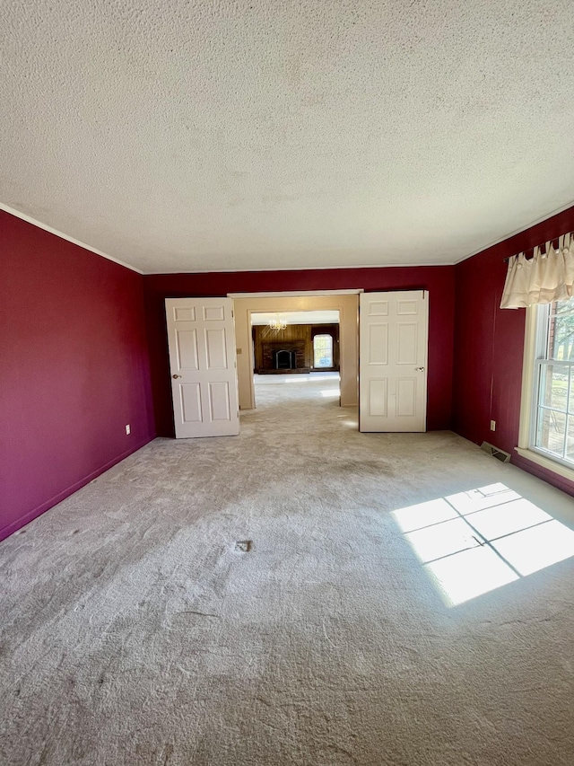 unfurnished living room featuring a textured ceiling and light carpet