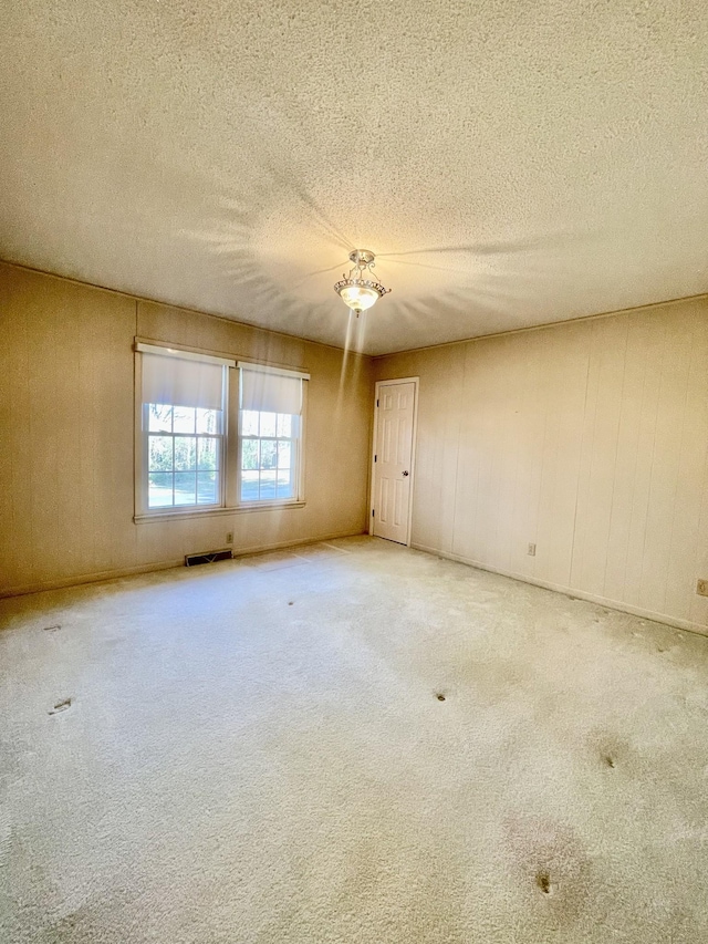 carpeted spare room with a textured ceiling