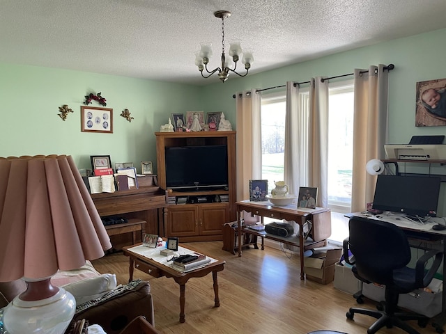 home office with light hardwood / wood-style floors, a textured ceiling, and a chandelier