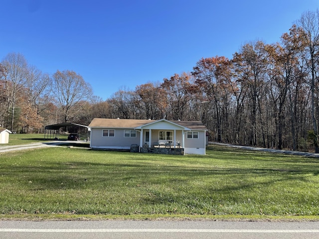 view of front facade with covered porch, a front lawn, and a carport