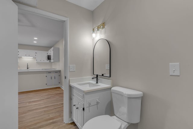 bathroom with wood-type flooring, tasteful backsplash, toilet, and sink