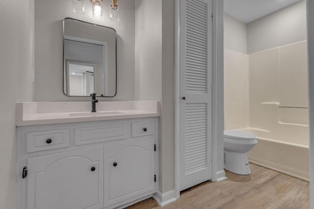 full bathroom featuring vanity, toilet, wood-type flooring, and shower / tub combination