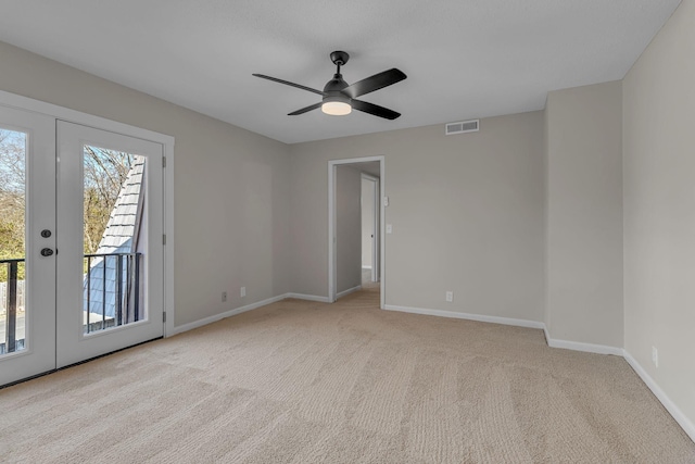 carpeted empty room featuring ceiling fan and french doors