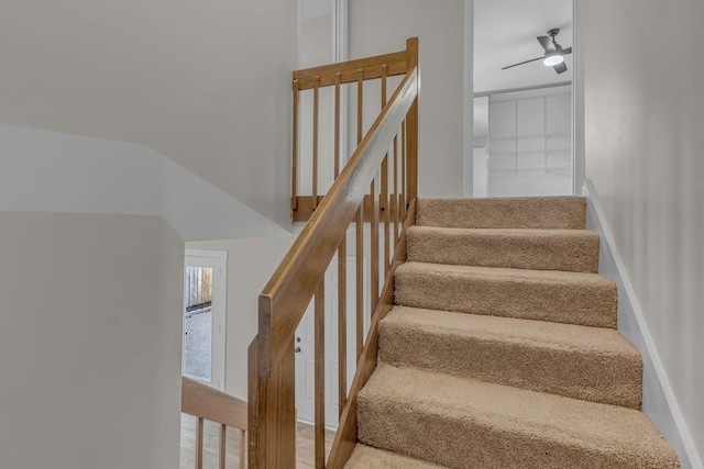 stairs with hardwood / wood-style floors and ceiling fan