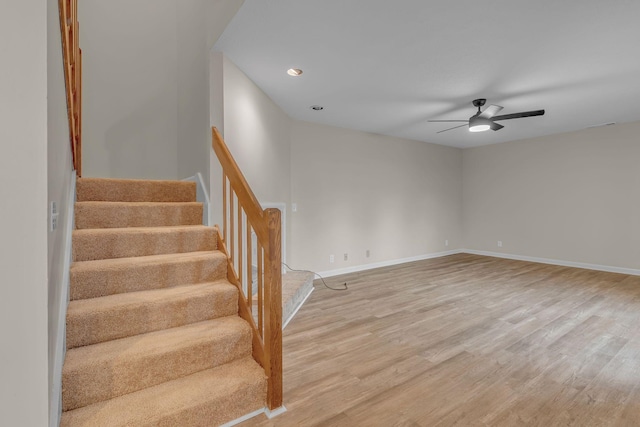 stairway with hardwood / wood-style flooring and ceiling fan