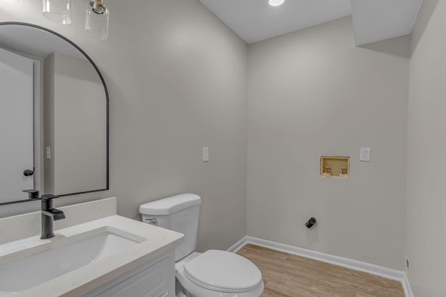 bathroom with vanity, toilet, and wood-type flooring