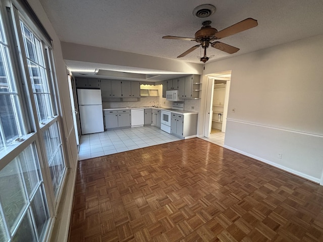 kitchen with tile patterned floors, a textured ceiling, white appliances, ceiling fan, and gray cabinets