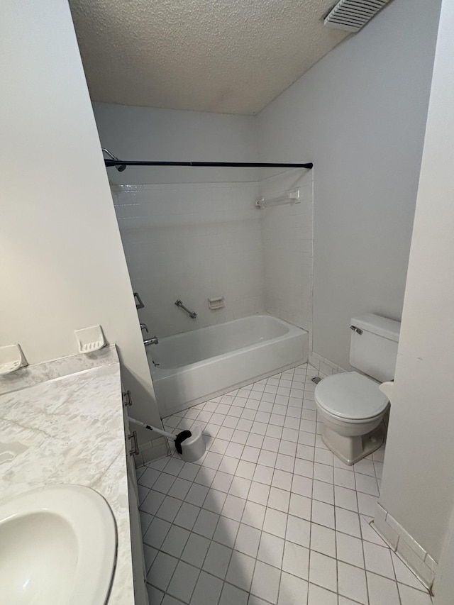 full bathroom with toilet, vanity, a textured ceiling, and tile patterned floors