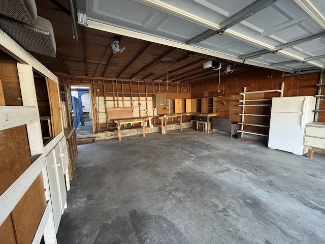 garage featuring white refrigerator and a garage door opener