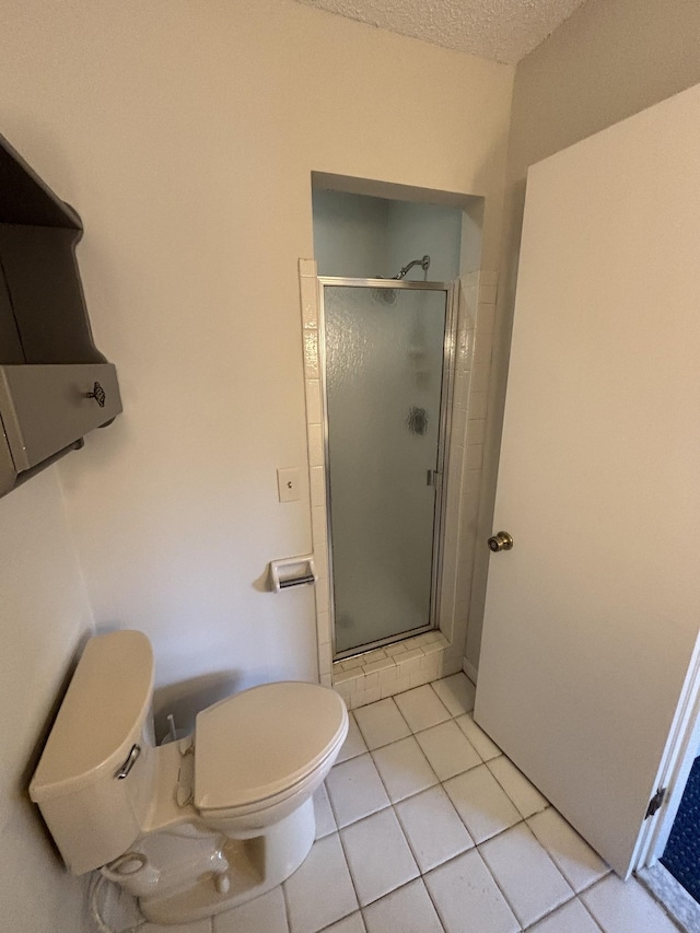 bathroom with tile patterned flooring, a shower with shower door, a textured ceiling, and toilet