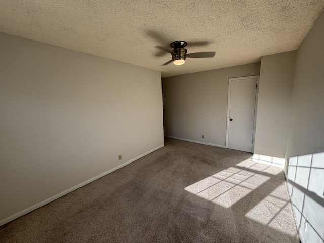 spare room with ceiling fan, light colored carpet, and a textured ceiling