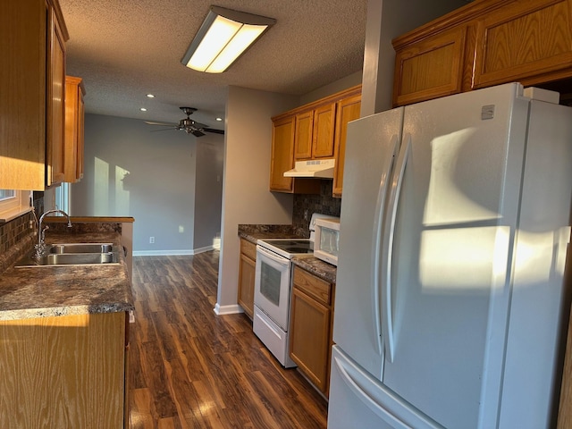 kitchen with dark hardwood / wood-style flooring, white appliances, sink, and tasteful backsplash