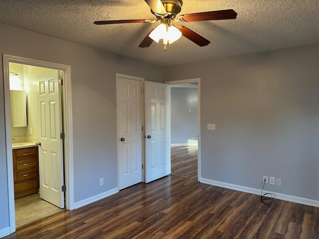 unfurnished bedroom featuring a textured ceiling, connected bathroom, ceiling fan, and dark hardwood / wood-style floors