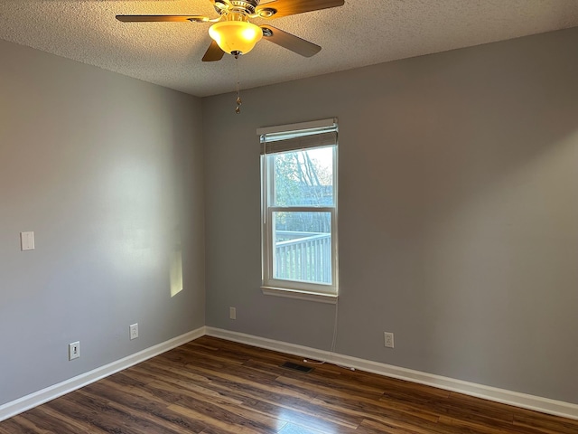 spare room with a textured ceiling, dark hardwood / wood-style floors, and ceiling fan