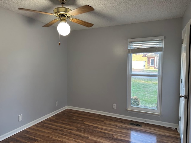 unfurnished room featuring plenty of natural light, dark hardwood / wood-style floors, and a textured ceiling