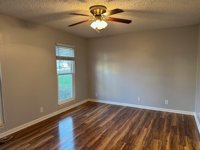 empty room with a textured ceiling and dark wood-type flooring