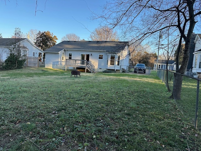 back of house with a lawn and a deck