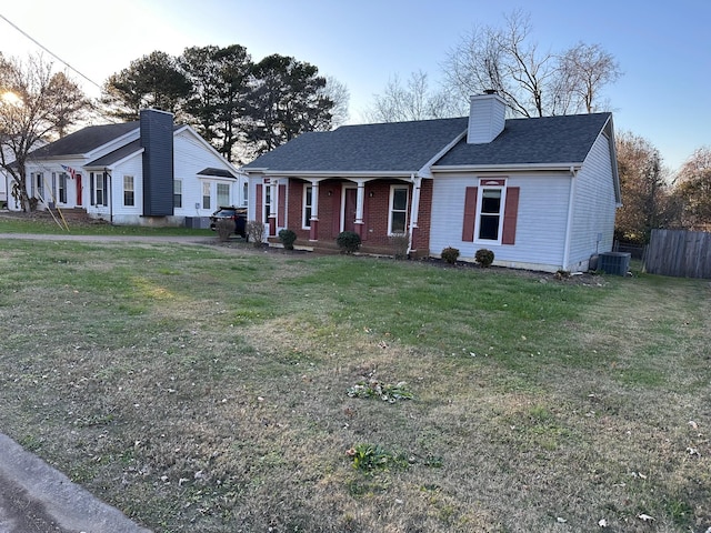 single story home with cooling unit, covered porch, and a front lawn