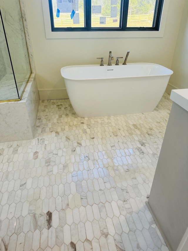 full bathroom featuring tile patterned flooring, a soaking tub, and baseboards