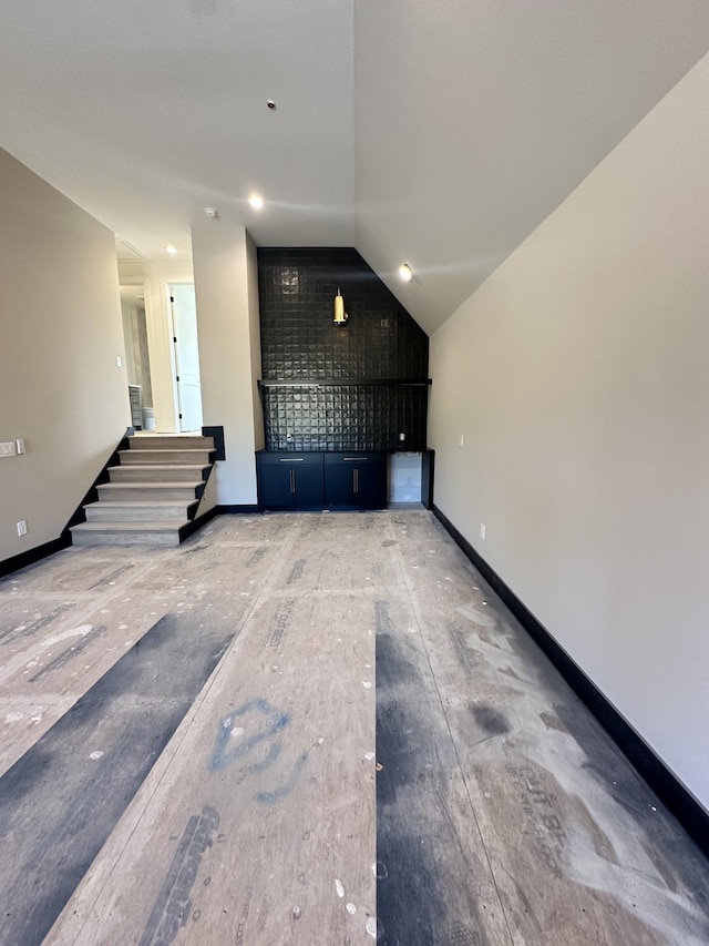 additional living space with lofted ceiling and baseboards