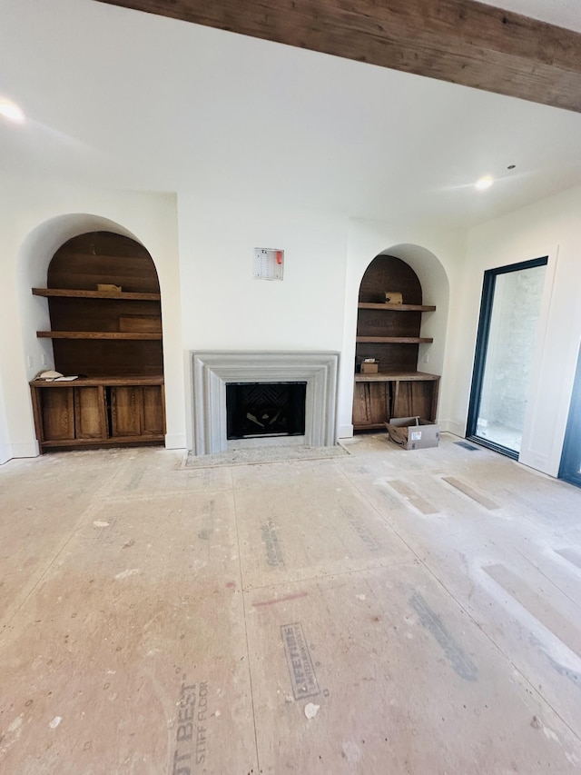 unfurnished living room with a fireplace with flush hearth, built in shelves, and baseboards