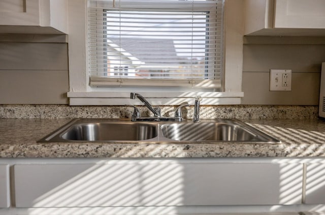 kitchen with light stone countertops and sink