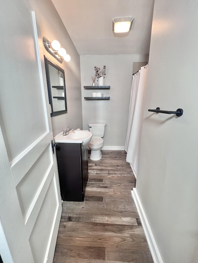 bathroom featuring vanity, toilet, and wood-type flooring