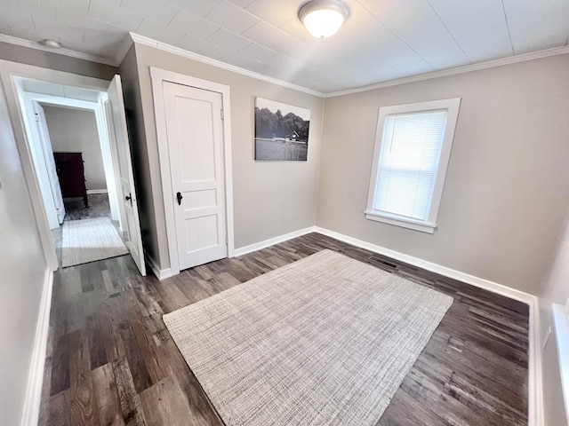 spare room featuring dark hardwood / wood-style flooring and ornamental molding