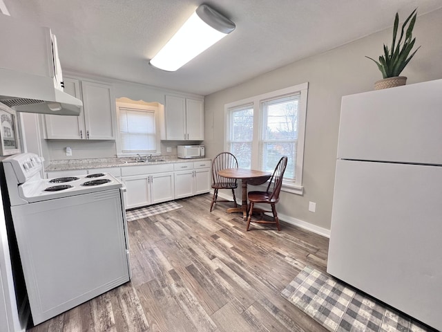 kitchen with light wood-type flooring, white appliances, ventilation hood, sink, and white cabinets