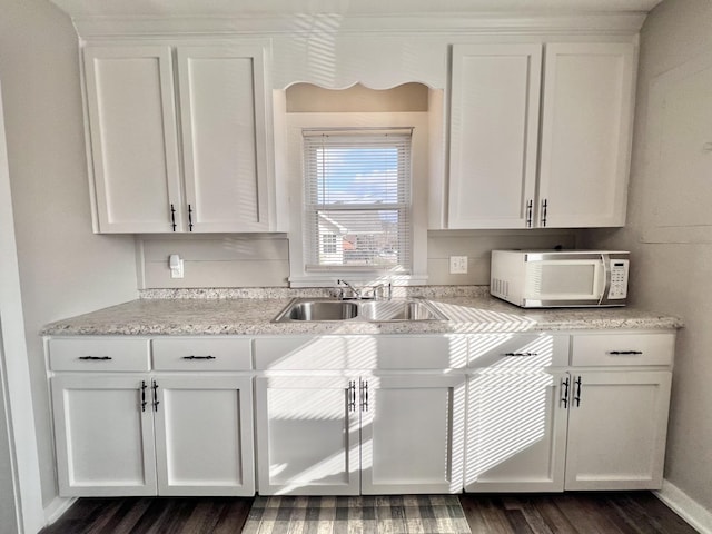 kitchen with white cabinetry, sink, and dark wood-type flooring