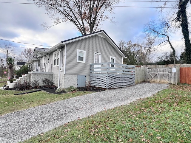 view of home's exterior featuring a lawn and a deck