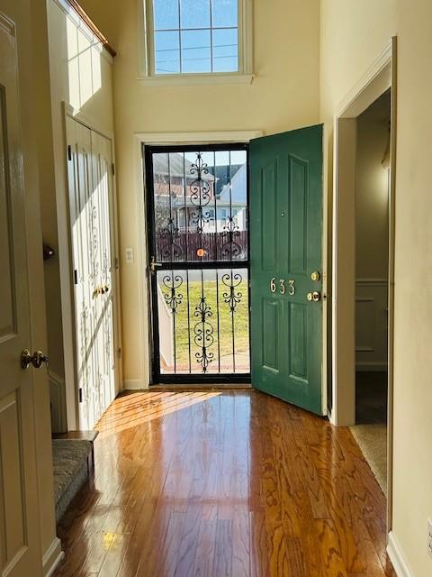 entryway featuring wood-type flooring and a high ceiling