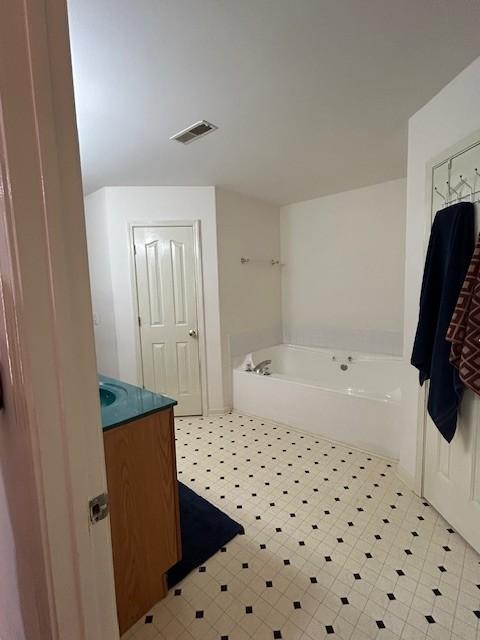 bathroom with a tub to relax in and vanity