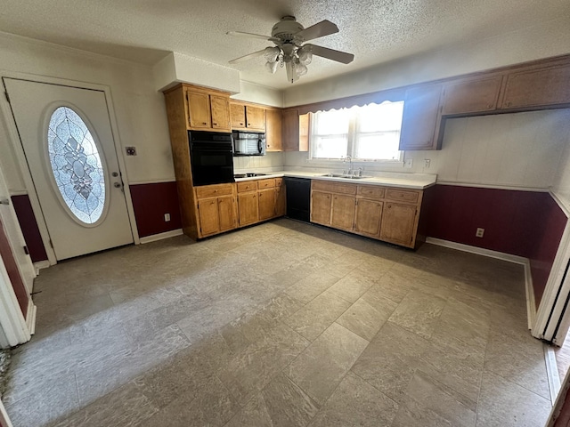 kitchen with sink, black appliances, a textured ceiling, and ceiling fan