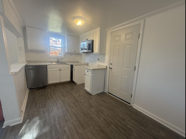 kitchen with sink, white cabinetry, dark wood-type flooring, and appliances with stainless steel finishes