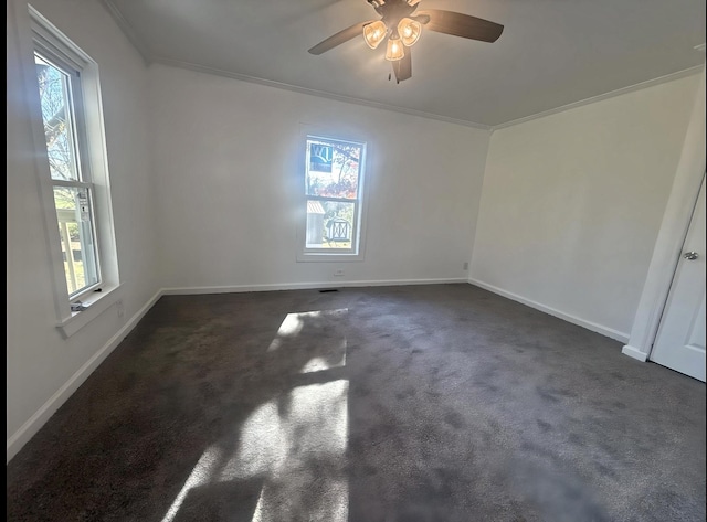 spare room with dark carpet, plenty of natural light, ornamental molding, and ceiling fan