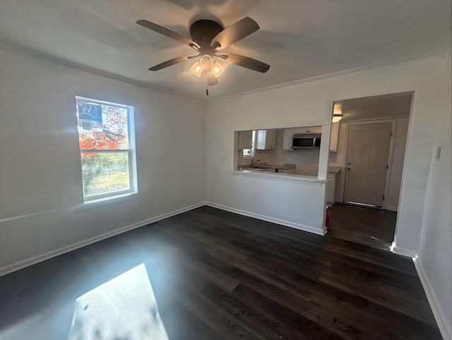 unfurnished living room featuring crown molding, ceiling fan, sink, and dark wood-type flooring