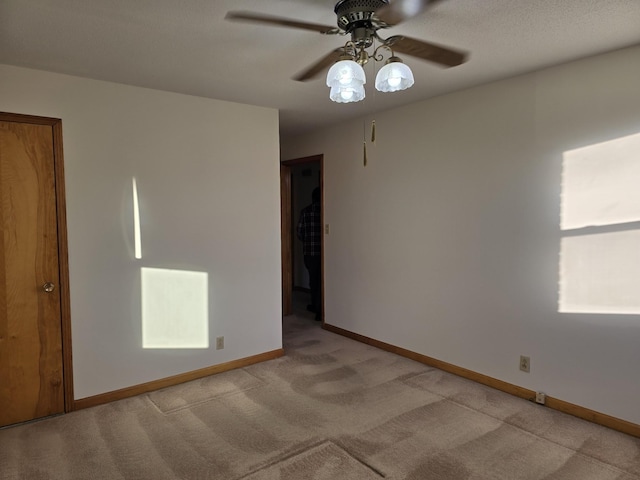 carpeted empty room featuring ceiling fan and a textured ceiling