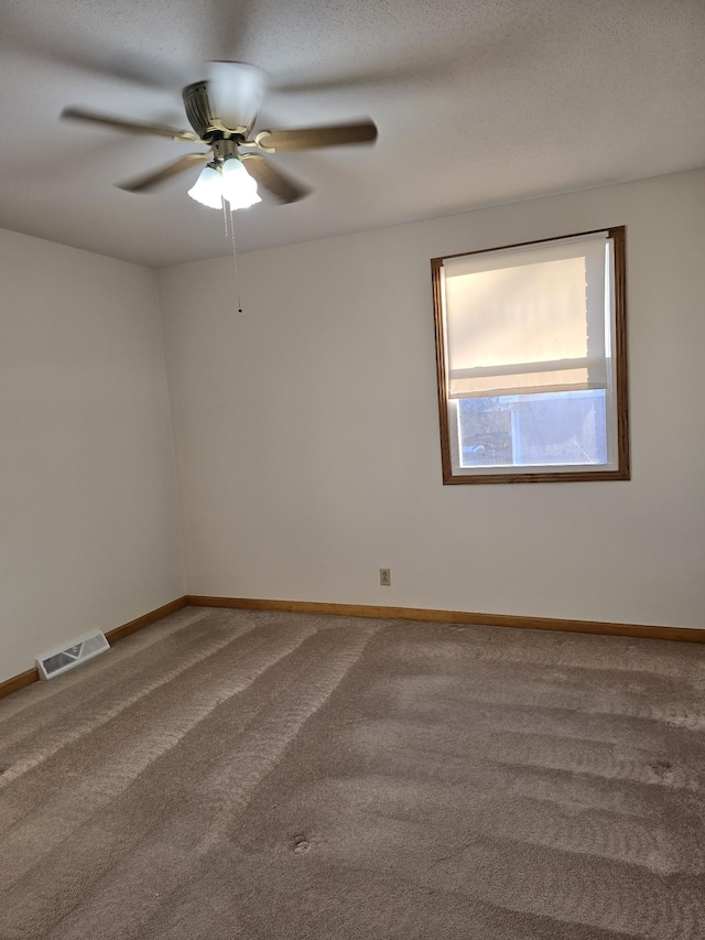 unfurnished room featuring a textured ceiling, carpet floors, and ceiling fan