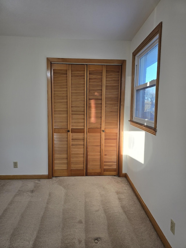 unfurnished bedroom with carpet and a closet