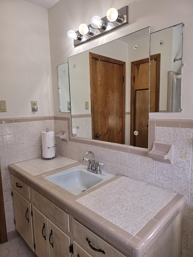 bathroom with tile patterned flooring, vanity, and tile walls