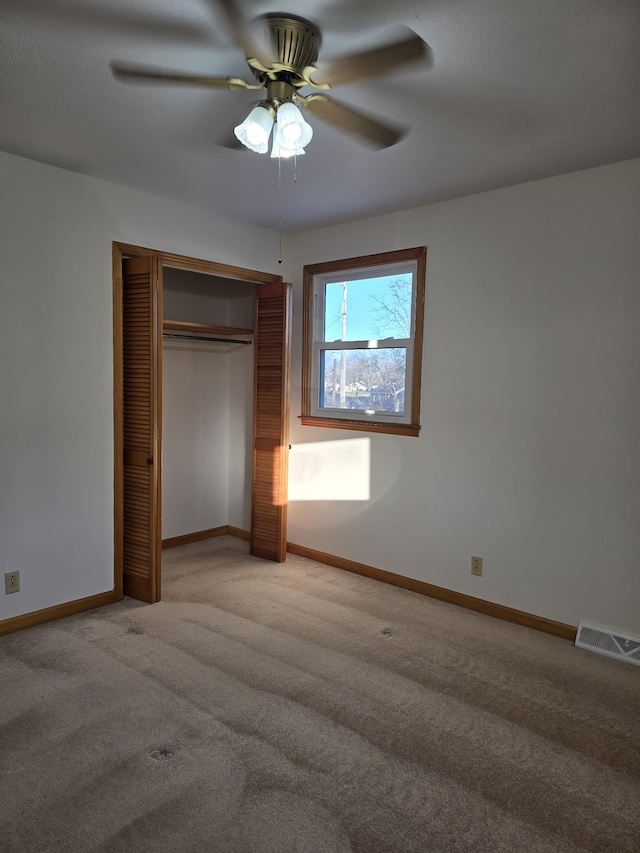 unfurnished bedroom with ceiling fan, carpet floors, and a closet