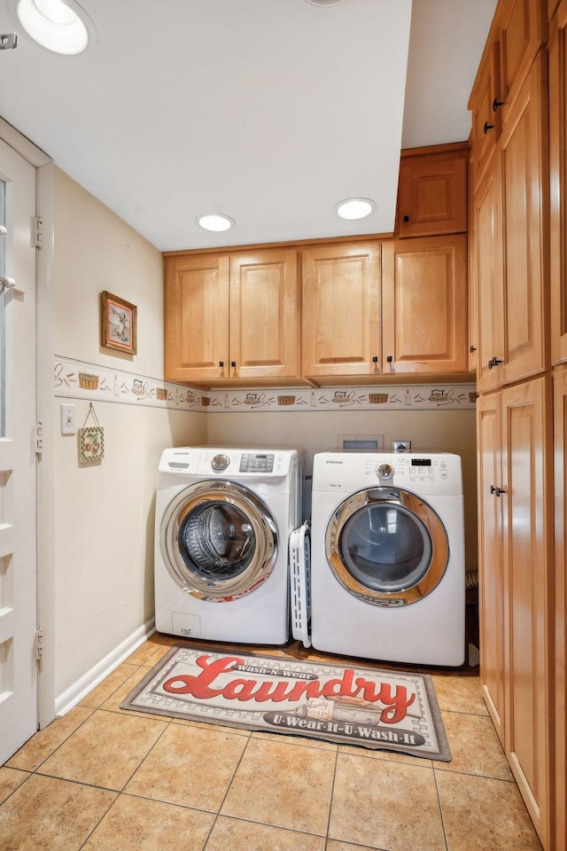 washroom featuring washer and dryer, cabinets, and light tile patterned floors