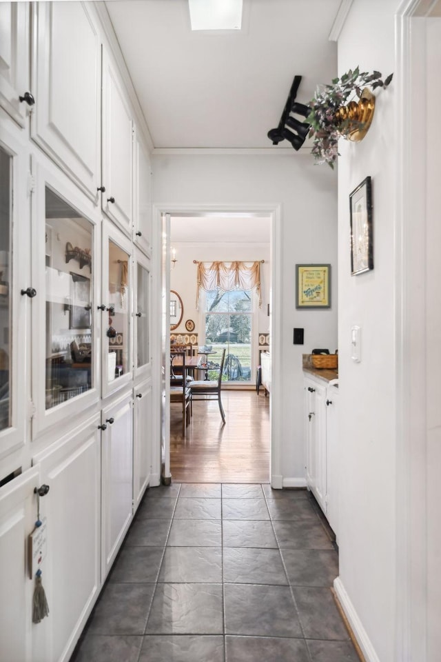 hall with dark hardwood / wood-style flooring and crown molding