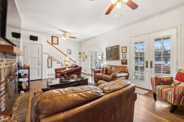 living room featuring french doors, ceiling fan, crown molding, and wood-type flooring