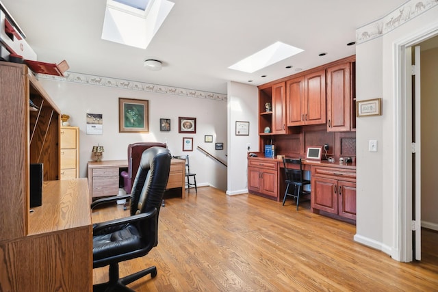 office space with built in desk and light wood-type flooring