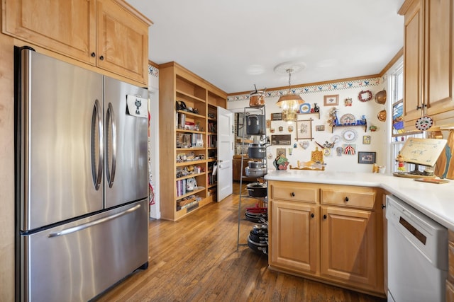 kitchen with dark wood-type flooring, stainless steel fridge, white dishwasher, decorative light fixtures, and light brown cabinetry