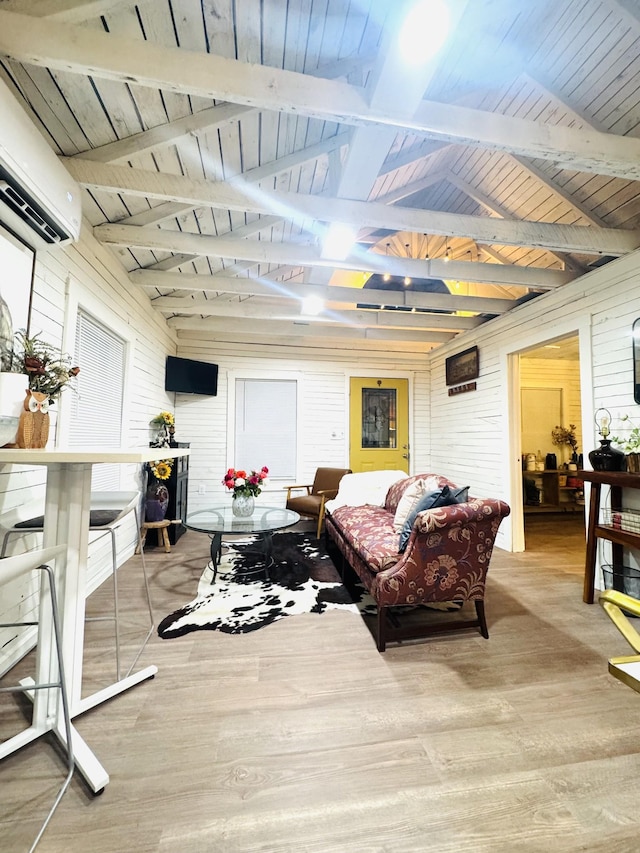 living area with hardwood / wood-style flooring, a wall unit AC, wooden ceiling, and beam ceiling